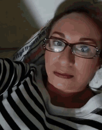 a woman wearing glasses and a striped shirt