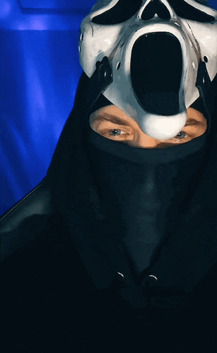 a person is wearing a scream mask and a black hood