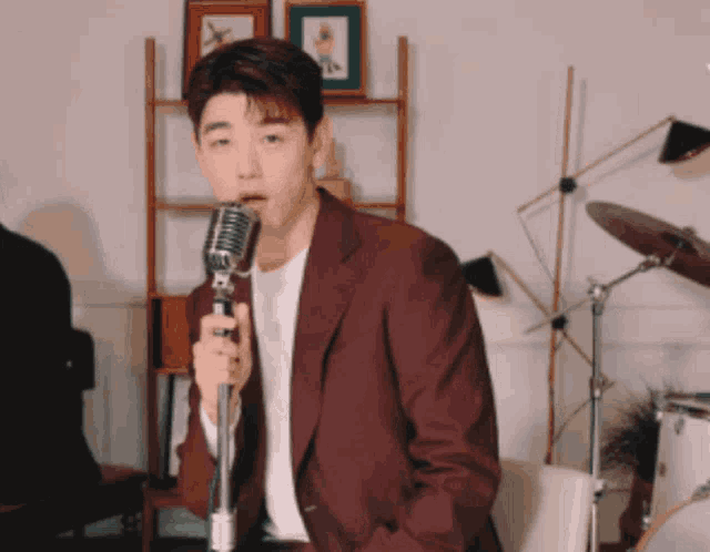 a man in a red suit singing into a microphone