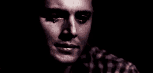 a man is covering his face with his hand while crying .