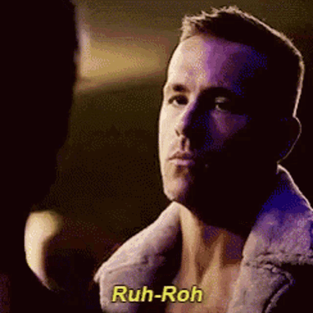 a man without a shirt is talking to another man and the words ruh-roh are visible on the screen .