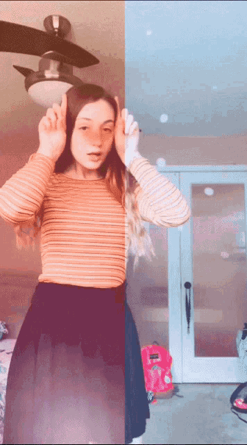 a girl standing in front of a ceiling fan