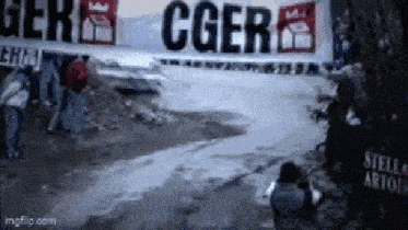 a man taking a picture in front of a sign that says cgers