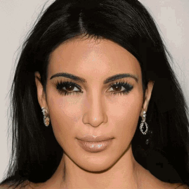 a close up of a woman 's face with earrings on