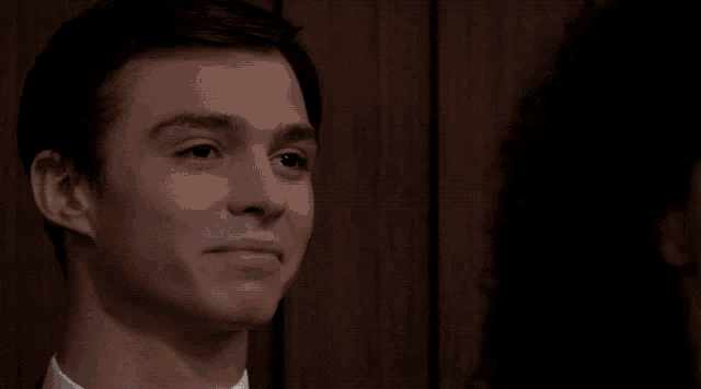 a close up of a man 's face with a woman behind him