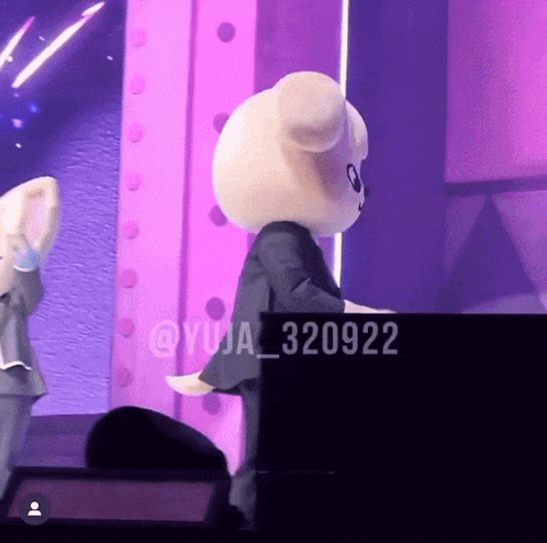 a teddy bear is standing in front of a piano with the number 320922 on it
