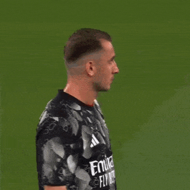 a man wearing a black and white adidas shirt looks at the camera