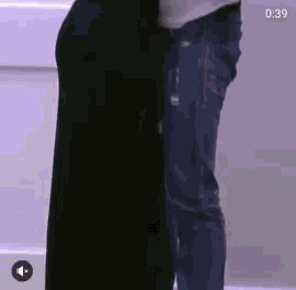 a man is standing next to a woman in a black dress and jeans .