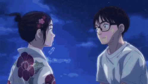 a boy and a girl are looking at each other while a fireworks display is going on in the background .
