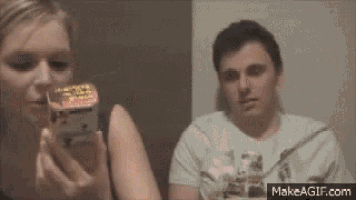 a man and a woman are looking at a box that says ' makeagif.com ' on it