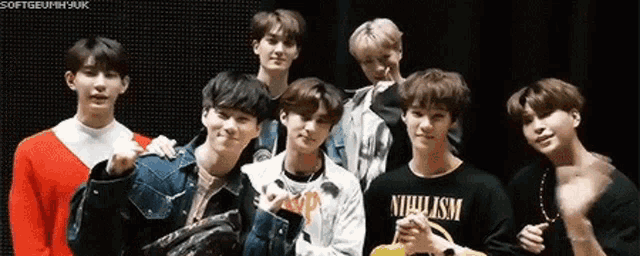 a group of young men are posing for a picture together and one of them is wearing a shirt that says nihilism .