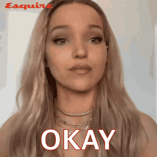 a woman wearing a necklace says okay in red letters