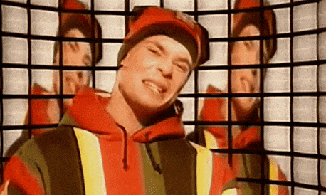 a man wearing a red hat and a striped hoodie is standing in front of a grid .