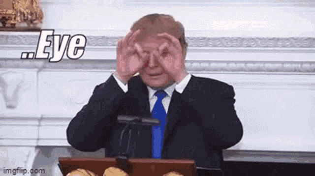 a man in a suit and tie is covering his eyes with his hands and the word eye is above him