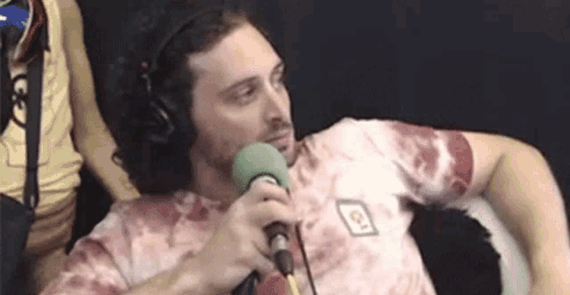 a man is sitting in front of a microphone wearing headphones .