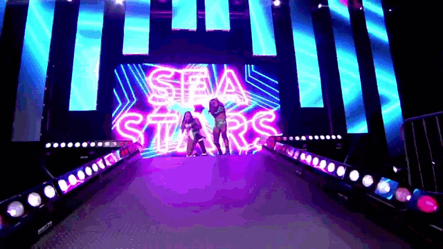 a couple of women are standing in front of a stage that says sea stars