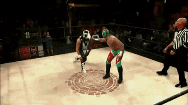 two wrestlers are fighting in a wrestling ring with a referee watching .