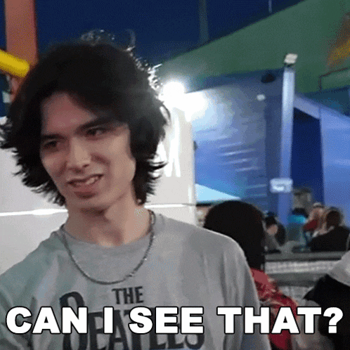 a man wearing a shirt that says the beatles is asking " can i see that "