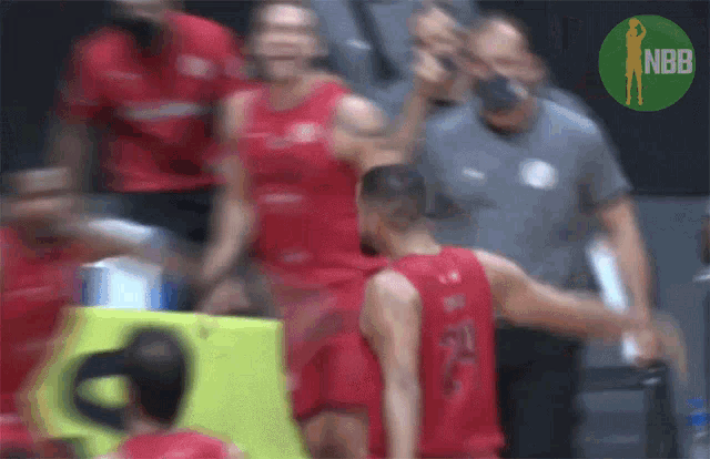 a blurry picture of a basketball game with a nbb logo in the background