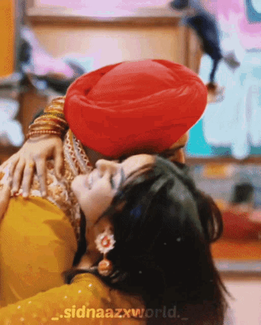 a man in a red turban is holding a woman in a yellow dress