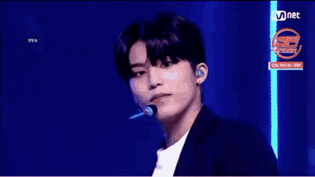 a young man is standing on a stage with a microphone in his ear .