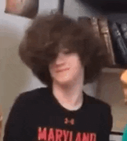 a young man with a large afro is wearing a maryland shirt .