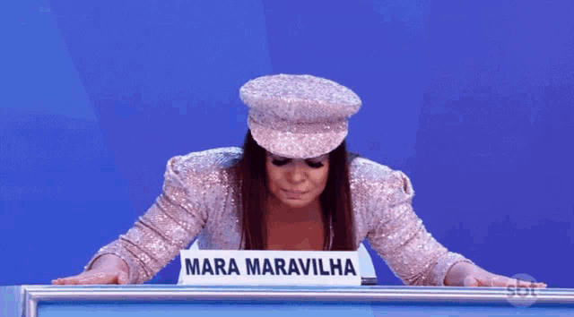 a woman wearing a hat and a sign that says " mara maravilha "