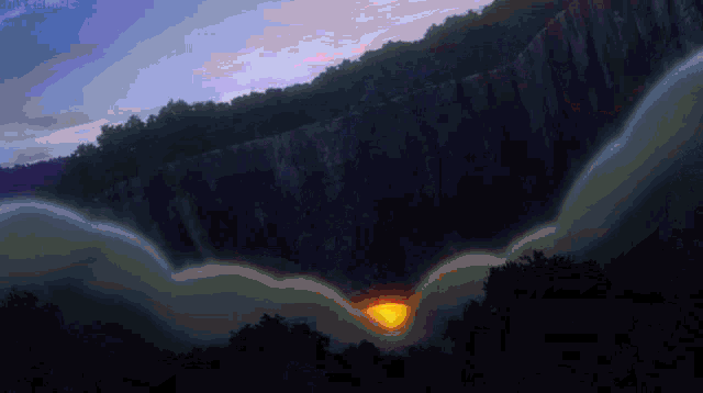 a sunset over a cliff with trees on the side of it