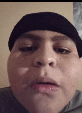 a close up of a person 's face wearing a black hat