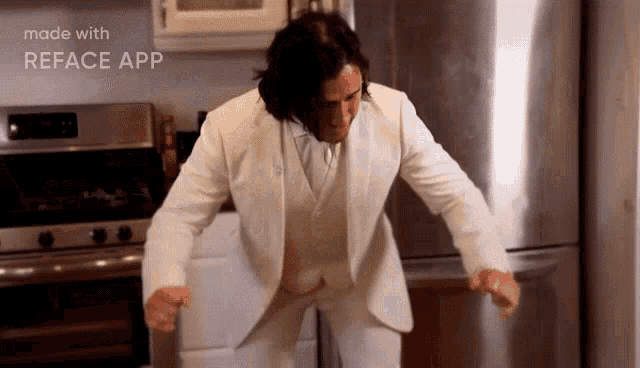a man in a white suit is dancing in a kitchen with the words made with reface app behind him