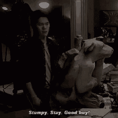 a man is standing next to a statue that says stump stay good boy