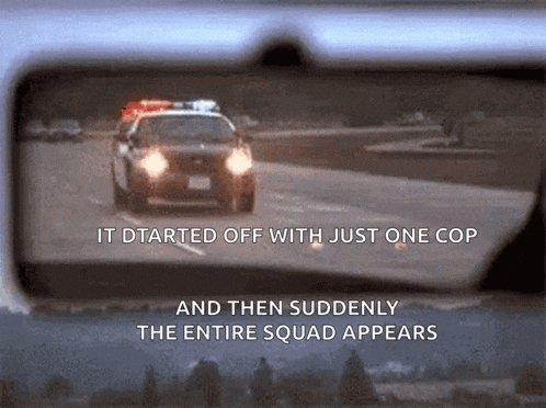 a rear view mirror shows a police car driving down a highway