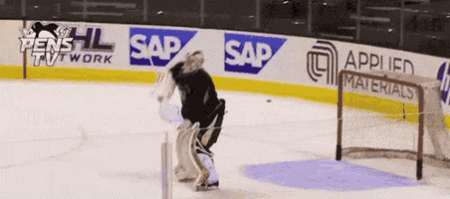 a hockey goalie stands in front of a wall that says sap on it
