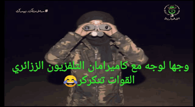 a man in a camouflage jacket is looking through binoculars in arabic