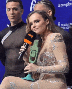 a woman is holding a microphone with the word rtve on it