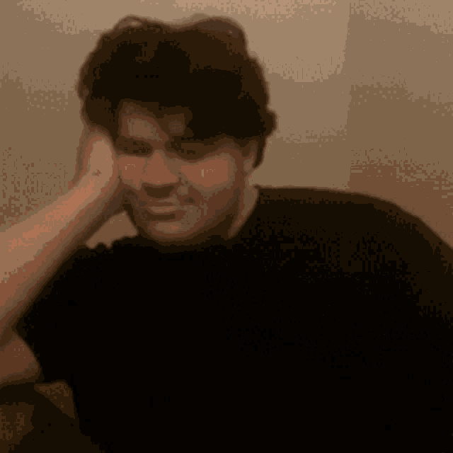 a blurry picture of a man in a black shirt with his arm outstretched