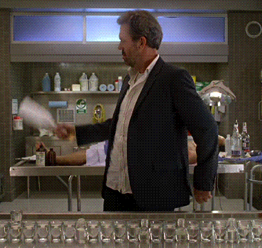 a man in a suit is standing in front of a shelf with bottles on it