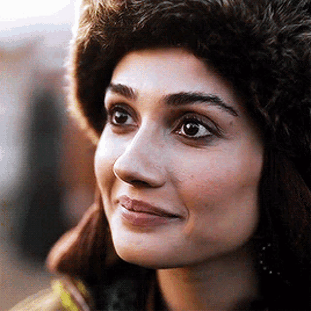a close up of a woman wearing a furry hat