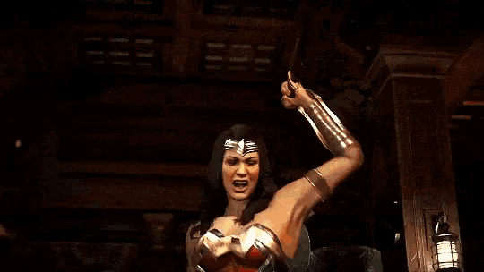 a woman in a wonder woman costume is standing in front of a fireball .
