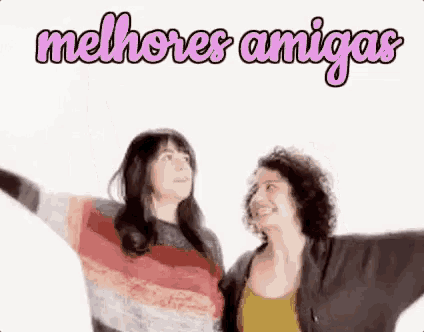 two women are standing next to each other with their arms outstretched and looking up .