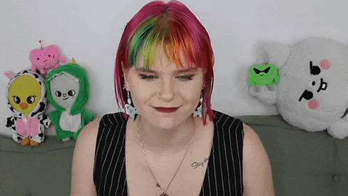 a woman with pink and green hair has a tattoo on her chest that says stay