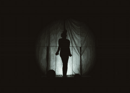 a silhouette of a person standing in the dark
