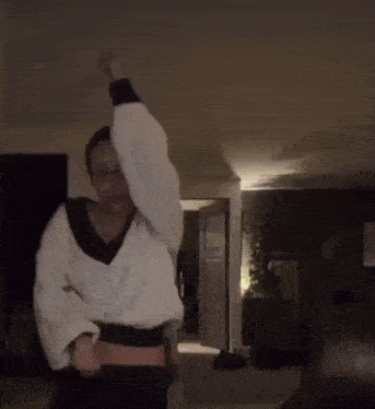 a woman in a white sweater is dancing in a living room .