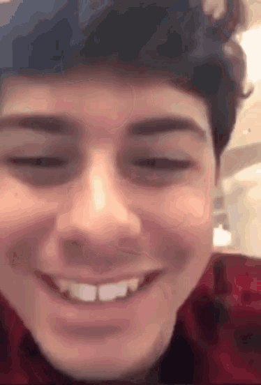 a close up of a person 's face with their eyes closed and smiling