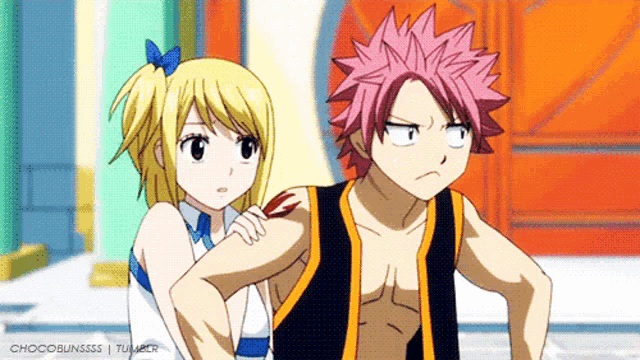 a boy and a girl are standing next to each other and the girl has a blue bow in her hair