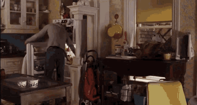 a man opens a refrigerator in a kitchen