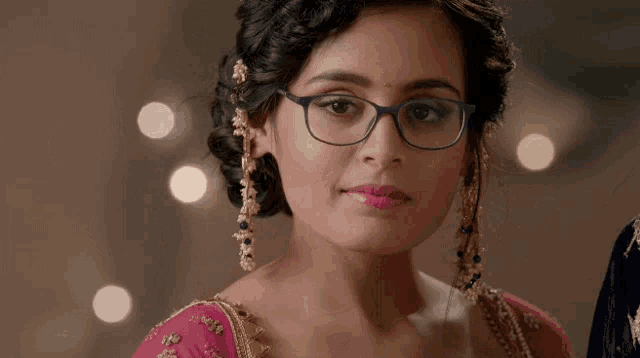 a woman wearing glasses looks at the camera