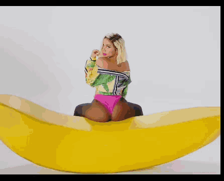 a woman is sitting on a banana with her legs crossed