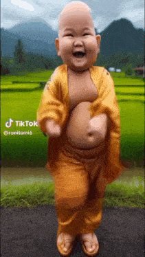 a baby dressed as a buddha is laughing and dancing .