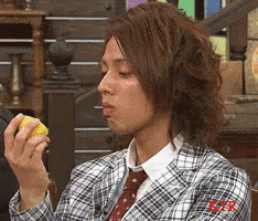 a man wearing a plaid jacket and tie is holding a lemon